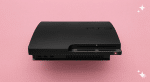 A professional internal power supply unit (PSU) for a PlayStation 3 Slim, displayed on a solid light pink background for Atlantis UK-wide console repair services.