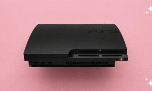 A professional internal power supply unit (PSU) for a PlayStation 3 Slim, displayed on a solid light pink background for Atlantis UK-wide console repair services.