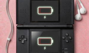 A replacement 3.5mm headphone jack component for a Nintendo 3DS XL, shown on a solid light pink background for Atlantis UK-wide console repair services.