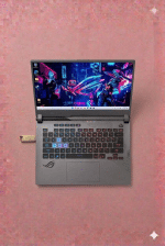 A professional micro-soldering repair of an Asus ROG gaming laptop USB 3.2 port, displayed on a solid light pink background for Atlantis Canterbury and UK-wide repair services.