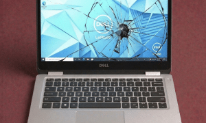 A premium replacement InfinityEdge 4K OLED and Full HD LCD display panel for a Dell laptop, positioned on a solid light pink background for Atlantis repair services.