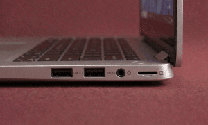 A close-up of a high-quality replacement internal USB-C and USB 3.0 port assembly for a Dell laptop motherboard, positioned on a solid light pink background for Atlantis repair services.