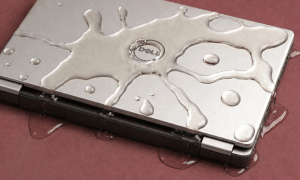 Detailed internal view of a Dell laptop motherboard showing specialist corrosion removal from a spilled liquid, positioned on a solid light pink background for Atlantis repair services.