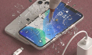 A professional technician installing a high-quality replacement Liquid Retina LCD screen for the iPhone 11, shown on a solid light pink background for Atlantis repair services.