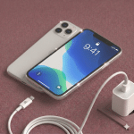 A professional technician installing a premium replacement Super Retina XDR OLED screen for the iPhone 11 Pro, shown on a solid light pink background for Atlantis repair services.