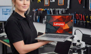 A high-precision view of a technician repairing a Lenovo laptop motherboard using micro-soldering tools under a digital microscope, set against a solid light pink background for Atlantis repair services.