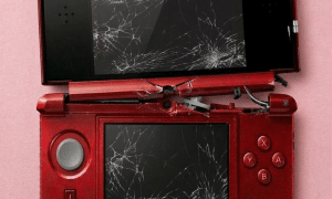 A replacement inner hinge barrel and black plastic mid-frame housing for a Nintendo 3DS XL, shown on a solid light pink background for Atlantis console repair services.