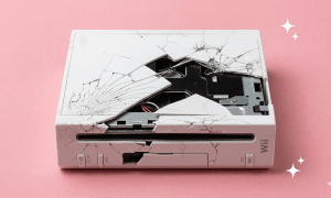A premium high-gloss white replacement outer shell housing for a Nintendo Wii console, displayed on a solid light pink background for Atlantis UK-wide restoration services.