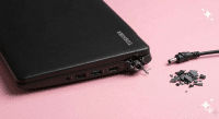 A premium replacement DC power jack with wire harness for a Toshiba Satellite laptop, displayed on a solid light pink background for Atlantis UK-wide repair services.