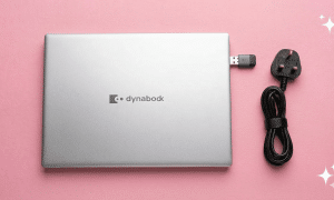 A professional micro-soldering repair of a Toshiba laptop motherboard USB-A port and HDMI socket, displayed on a solid light pink background for Atlantis repair services.