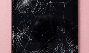 A premium replacement glass digitiser and front touch panel for a classic 1st Generation iPad (2010), shown on a solid light pink background for Atlantis vintage iPad repair services.