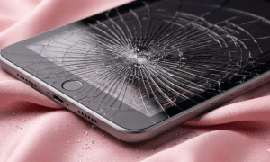 A premium replacement 9.7-inch Retina LCD display panel for an iPad 6th Gen (2018), shown on a solid light pink background for Atlantis repair services.