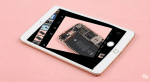 A high-quality replacement 8MP rear-facing camera module for an iPad 6th, 7th, 8th, or 9th generation, shown on a solid light pink background for Atlantis repair services.