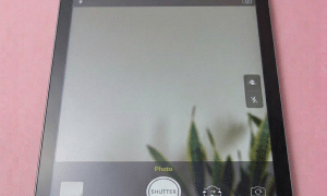 A professional-grade replacement front-facing FaceTime camera and rear 12MP camera sensor for an iPad, shown on a solid light pink background for Atlantis repair services.