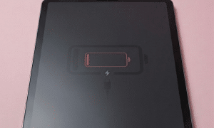 A high-capacity replacement iPad lithium-polymer battery displayed on a solid light pink background for Atlantis repair services, representing a fix for a flat battery that will no longer hold a charge.