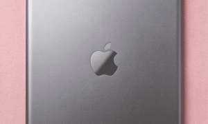 A premium replacement aluminium rear housing for an iPad Mini, shown on a solid light pink background for Atlantis iPad Mini back repair services.