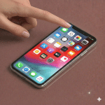 Close-up of a replacement front-facing camera module and TrueDepth sensor assembly for the iPhone 11, positioned on a solid light pink background for Atlantis repair services.