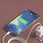 Close-up of a high-quality replacement Lightning charging port and microphone flex cable assembly for the iPhone 11 series, positioned on a solid light pink background for Atlantis repair services.