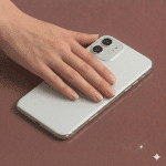 Close-up of precision-cut sapphire glass replacement rear camera lenses for the iPhone 11, 11 Pro, and 11 Pro Max, shown on a solid light pink background for Atlantis repair services.