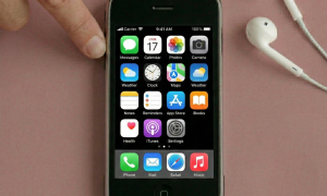 Close-up of a high-quality replacement front glass digitiser and internal LCD display assembly for the iPhone 3G and 3GS, positioned on a solid light pink background for Atlantis repair services.