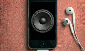 Close-up of the internal loudspeaker and earpiece speaker components for the iPhone 3G and 3GS, positioned on a solid light pink background for Atlantis repair services.