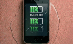 Close-up of an internal logic board for the iPhone 3G and 3GS being treated for liquid damage and corrosion, positioned on a solid light pink background for Atlantis repair services.
