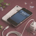 Detailed internal view of an iPhone 4S logic board undergoing specialist corrosion removal and chemical cleaning, positioned on a solid light pink background for Atlantis repair services.