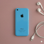 Close-up of the rear aluminium housing and glass panels of an Apple iPhone 5S, positioned on a solid light pink background for Atlantis repair services.