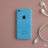 Close-up of the rear aluminium housing and glass panels of an Apple iPhone 5S, positioned on a solid light pink background for Atlantis repair services.
