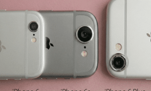 Close-up of the rear camera lens and flash on an Apple iPhone 6 and 6S series handset, set against a solid light pink background for Atlantis repair services.