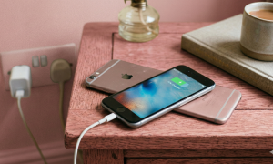 Close-up of a high-capacity internal replacement battery for the Apple iPhone 6 and 6S series, positioned on a solid light pink background for Atlantis repair services.