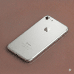 Close-up of a precision-cut sapphire crystal replacement rear camera lens for the iPhone 7, 8, and SE series, positioned on a solid light pink background for Atlantis repair services.