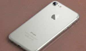 Close-up of a precision-cut sapphire crystal replacement rear camera lens for the iPhone 7, 8, and SE series, positioned on a solid light pink background for Atlantis repair services.