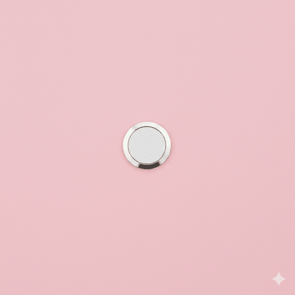 Professional 1:1 square studio photograph showing a close-up of the circular Home Button (Touch ID sensor) on the bottom bezel of a silver iPhone 7, set against a solid light pink background for Atlantis repair services.