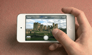 Close-up of the front and rear camera modules for the Apple iPod Touch 3, 4, 5, 6, and 7 series, positioned on a solid light pink background for Atlantis repair services.