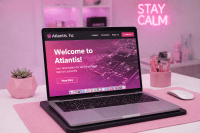 MacBook fan repair in a UK workshop with pink Atlantis theme, showing a MacBook on a repair mat in a professional setup.