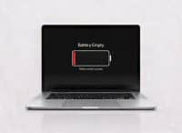 Front-view of a MacBook Pro displaying a "Battery Empty - Please connect to power" warning, signifying the need for a professional battery replacement at Atlantis.