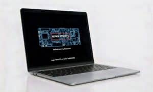 A professional view of a silver MacBook Air displaying a "Motherboard Fault Detected" diagnostic error with a logic board schematic, representing specialist motherboard repair services at Atlantis.