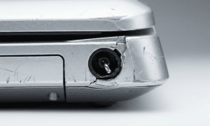 Close-up technical view of a broken DC charging port on a silver Sony Vaio laptop, showing a bent internal pin and cracked casing, isolated on the Atlantis signature studio background.