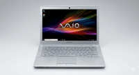 Professional photograph of a fully functional silver Sony Vaio laptop after repair, displaying a vibrant colorful wallpaper on a clean screen, isolated on the Atlantis graduated studio background.