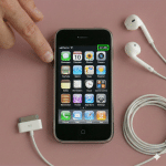 Close-up of a high-quality internal replacement lithium-ion battery for the iPhone 3G and 3GS, positioned on a solid light pink background for Atlantis repair services.