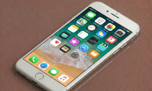 Close-up of a high-capacity replacement lithium-ion battery specifically for the iPhone 7 Plus and 8 Plus models, positioned on a solid light pink background for Atlantis repair services.