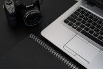 black camera beside a laptop