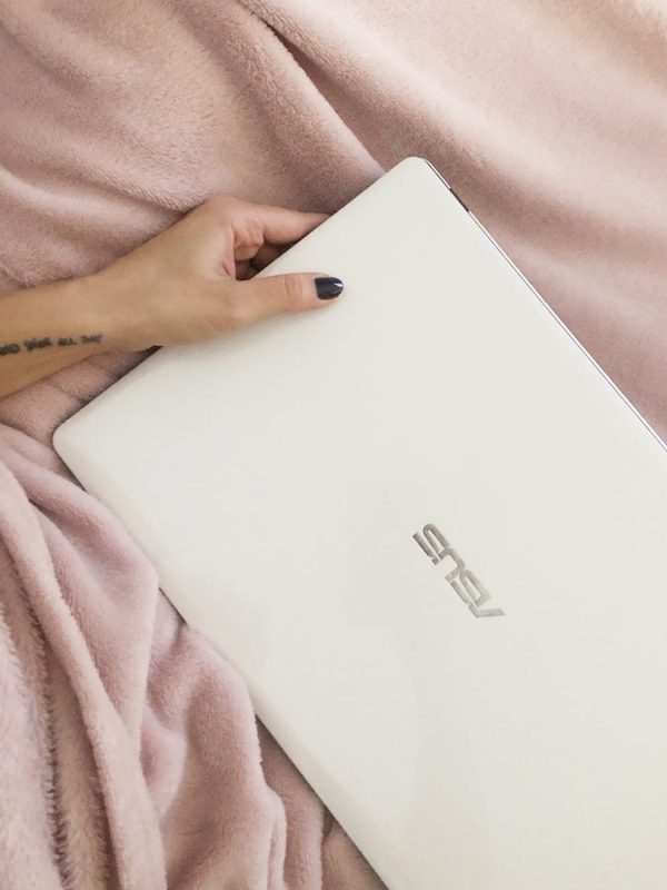 person holding a white asus laptop